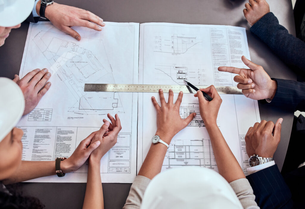 Gruppe von Architekten beim Brainstorming in einem Büro, sie besprechen einen Plan
